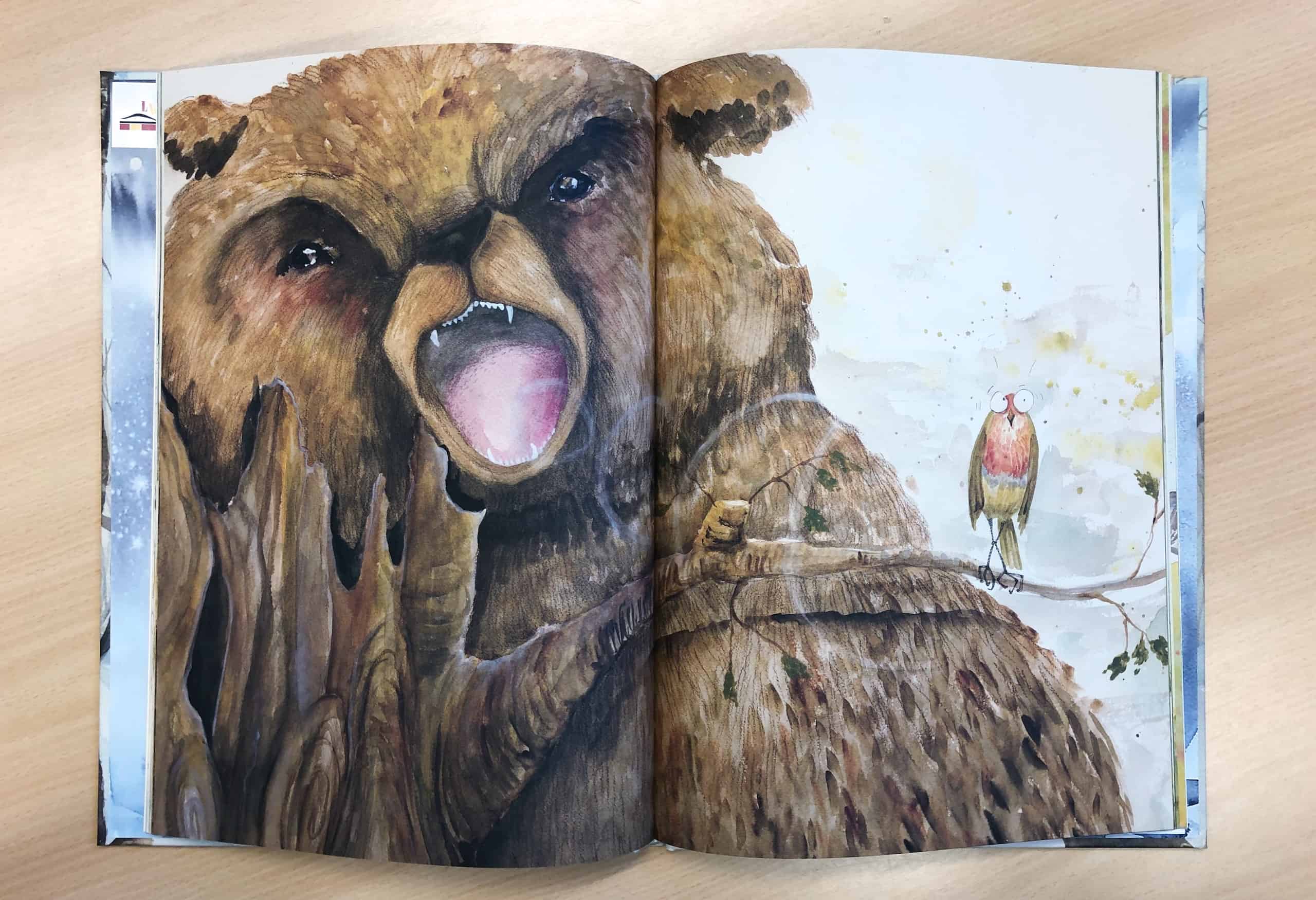 Esimerkkiaukeama Kuomaseni-kuvakirjasta: karhu ärjäisee, pikkulintu säikähtää