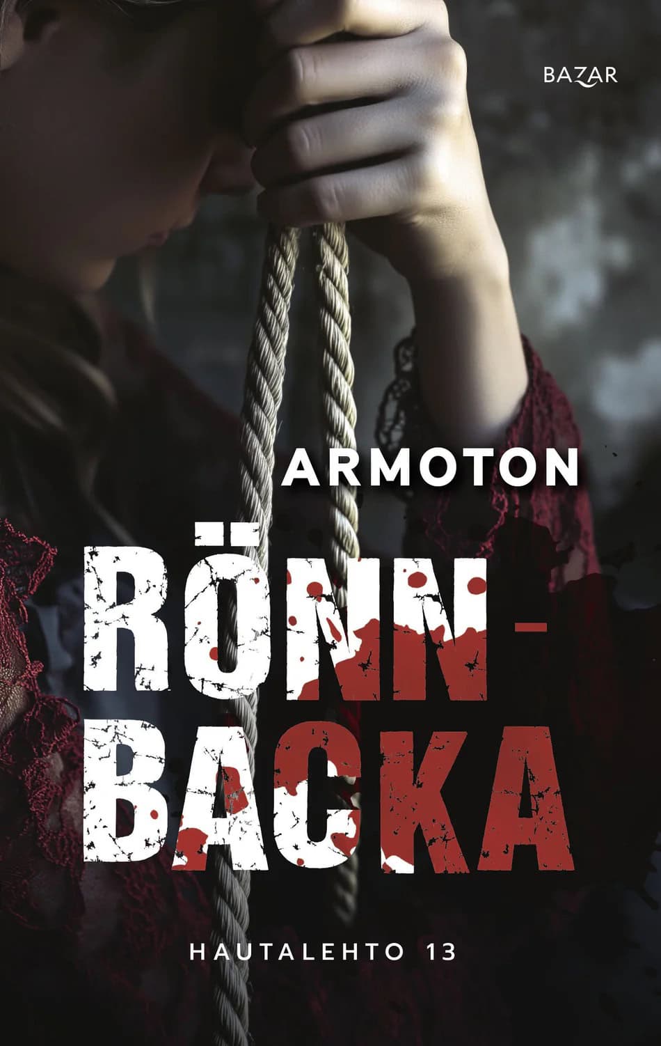 Armoton-kirjan kannessa viininpunaiseen pitsiin pukeutunut ihminen pitelee kädessään köyttä.