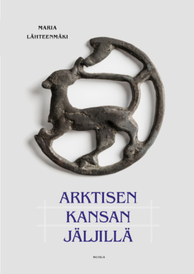 Arktisen kansan jäljillä -kirjan kannessa on valkoisella taustalla ympyrän mallinen metallinen epämääräistä eläinhahmoa esittävä esine.