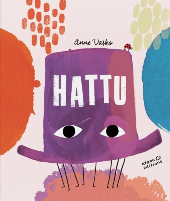 Hattu-kirjan kannessa on maalaus violetista silinterihatusta, jolla on isot silmät ja josta pilkottaa kahdeksan tikkumaista jalkaa.