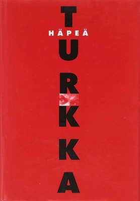 Häpeä-romaanin punaisessa kannessa lukee TURKKA isoin mustin kirjaimin. Kannen keskellä on pieni kuva tuijottavista silmistä.