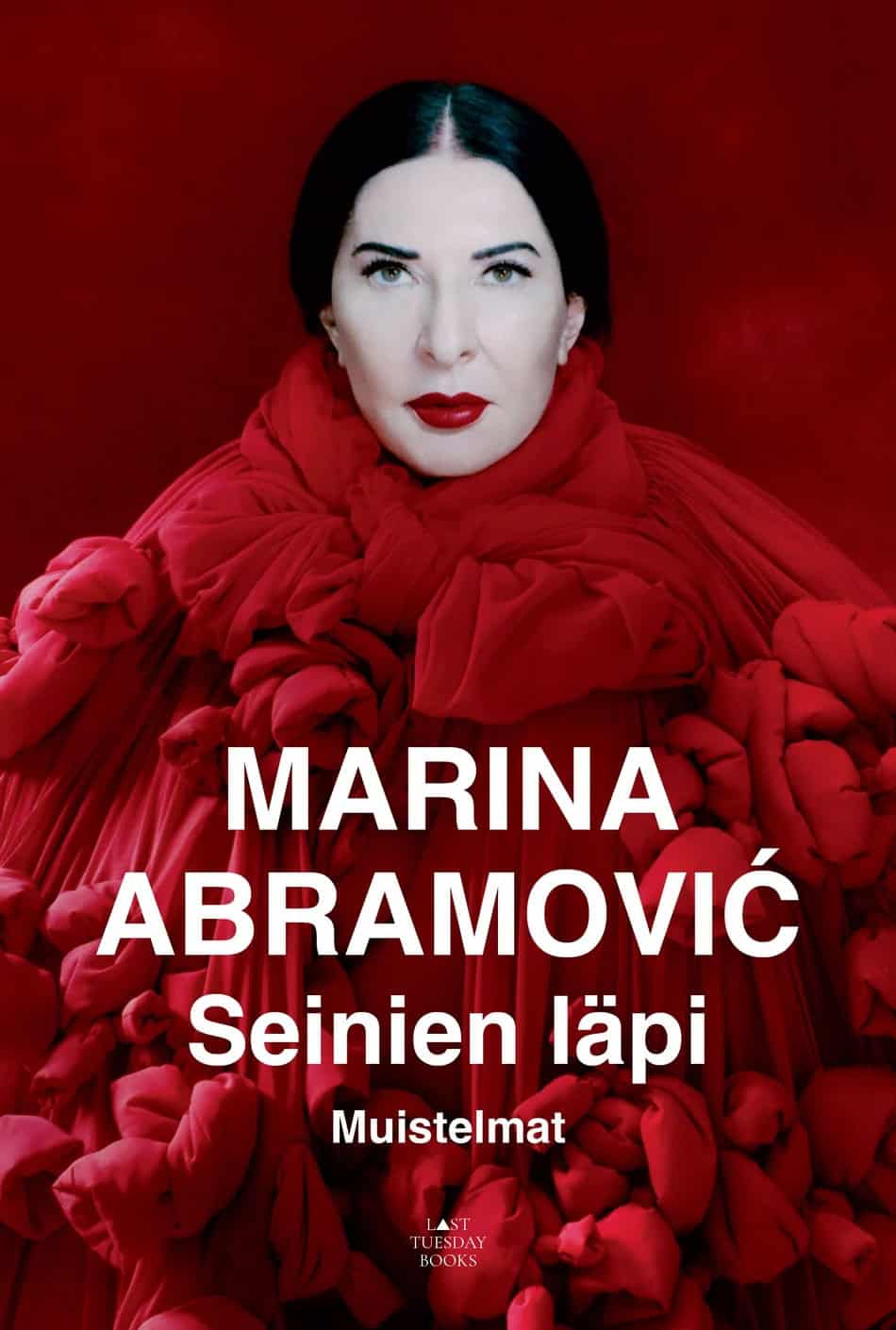 Seinien läpi -kirjan kannessa on valokuva Marina Abramovićisista punaisessa asussa.