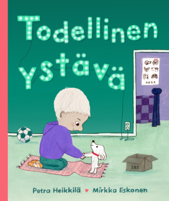 Todellinen ystävä -kirjan kannessa on piirros sisätiloista, joissa poika leikkii pienen valkoisen koiranpennun kanssa.