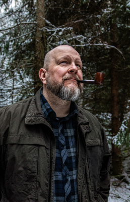 Tuomas Lius piippu suussa lumisessa metsässä