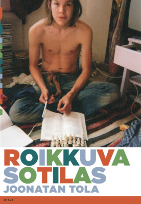 Roikkuva sotilas -kirjan kannessa on rakeinen valokuva Tolasta istumassa lattialla paidatta, edessään avonainen kirja ja shakkilauta.